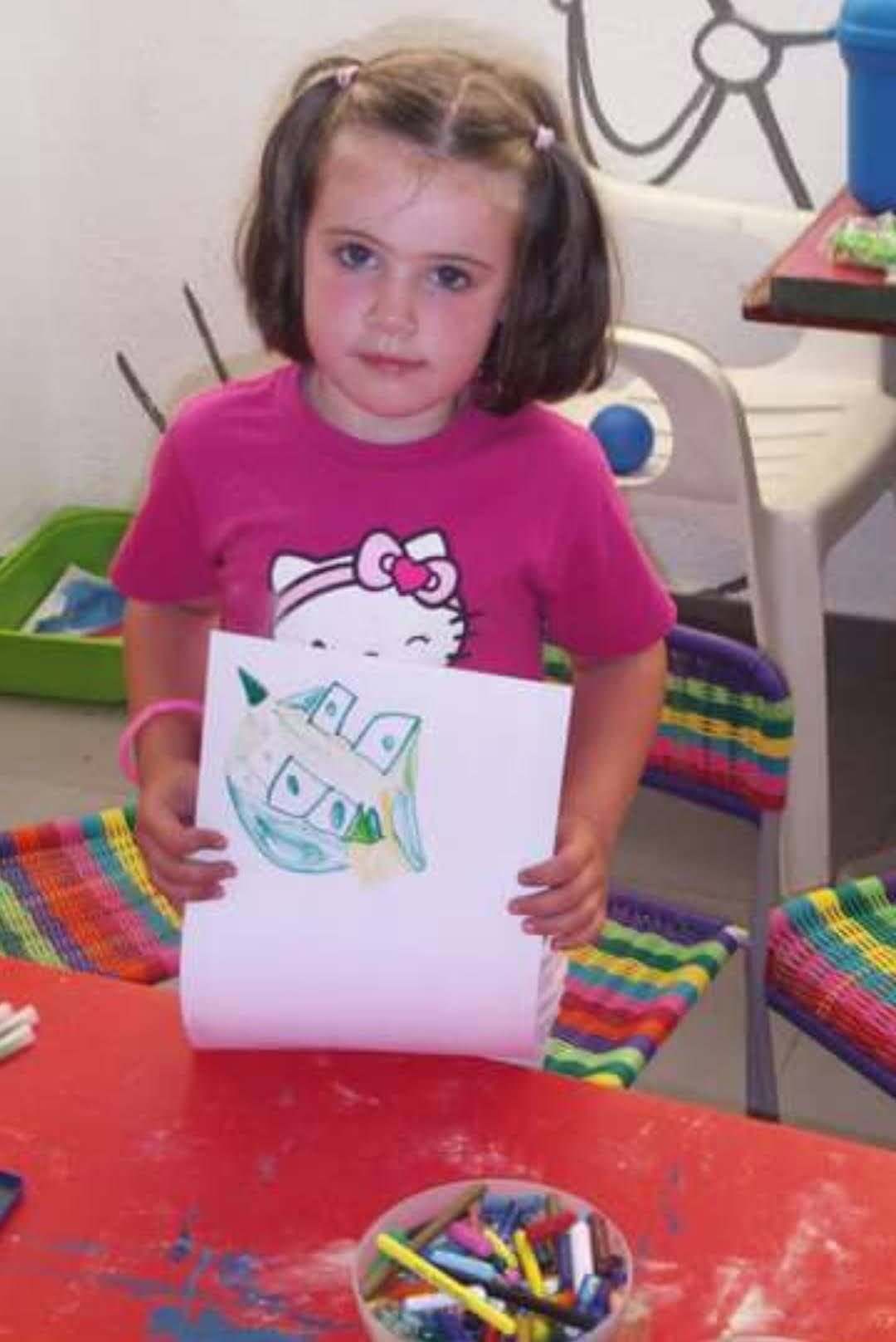 Lucia de pequeña enseñando un dibujo